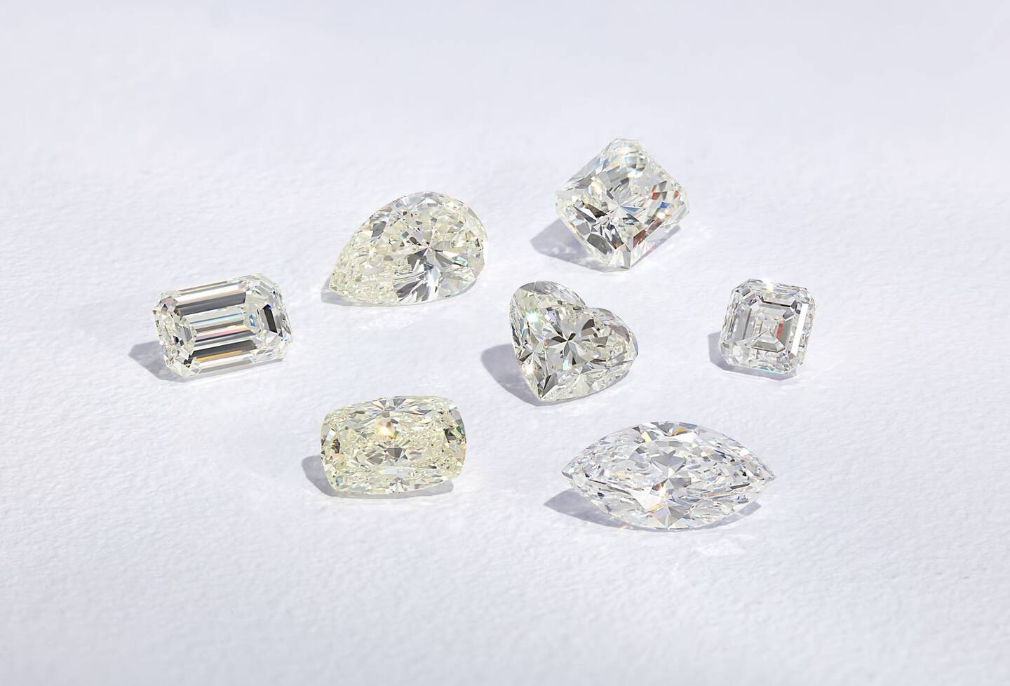 Loose diamonds in various shapes against a gray background